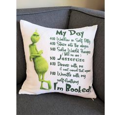 the grinch pillow is on top of a gray couch with words written in green