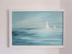 two sailboats in the ocean on a blue and white painting hanging on a wall