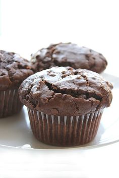 three chocolate muffins on a white plate