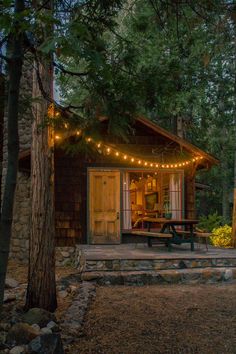 a small cabin with lights strung from the roof and trees around it, on instagram