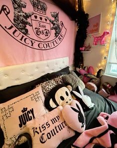 a bed topped with lots of pillows and stuffed animals