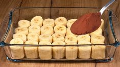 a glass container filled with sliced bananas and powdered cinnamon sitting on top of a wooden table