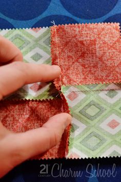 someone is cutting fabric with scissors on top of the cloth and another piece has been sewn