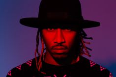 a man with dreadlocks wearing a black hat