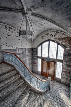 an old abandoned building with a staircase leading up to the door and window on the second floor