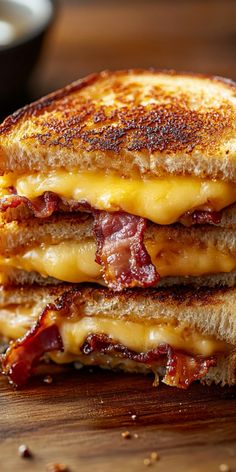 two grilled cheese sandwiches stacked on top of each other with bacon and melted cheese