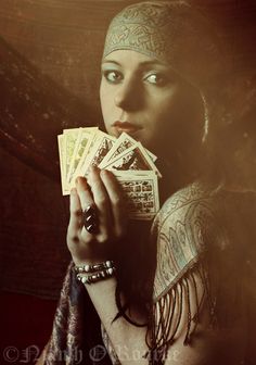 a woman holding money in her hand and looking at the camera with an intense look on her face