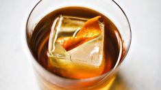 an orange slice is placed on top of the ice cubes in a glass filled with liquid