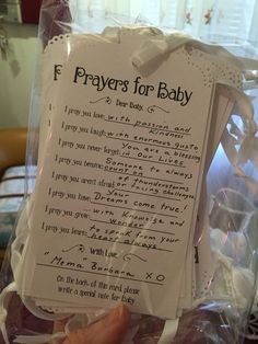 someone holding up a prayer for baby in a plastic bag with writing on the back