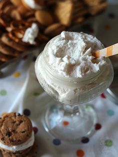 an ice cream sundae in a glass on a table with cookies and crackers