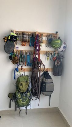 there is a rack with many different items on the wall and bags hanging from it