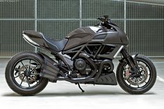 a motorcycle parked in a parking lot next to a wall with metal grilles on it