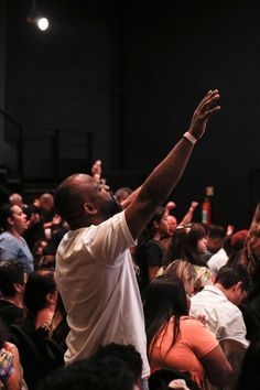 a man is reaching up to catch a frisbee in front of an audience