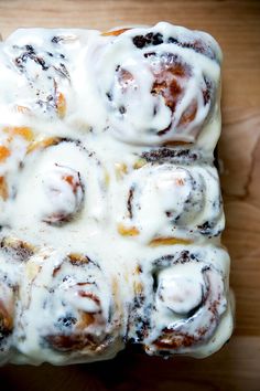 a cinnamon roll covered in icing sitting on top of a wooden table