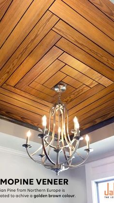 a chandelier hanging from the ceiling in a room with wood paneling on it