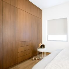 a white bed sitting next to a wooden wall