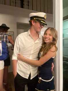 a young man and woman are hugging each other in front of the door at an event