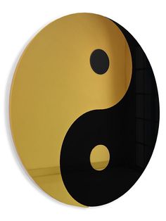 a black and yellow yin sign on a white wall