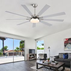 a living room with a couch, coffee table and ceiling fan in the middle of it