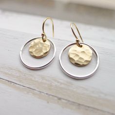 "Hammered 1/3\" gold medallions are encased by sterling silver hoops and dangle from gold filled French hook earwires. Rubber ear clutches included to avoid loss. ~ 1/2\" drop. Lightweight and easy to wear, these dainty earrings also make a great gift. They come in a cute box ready for giving. Dangle Earrings | Mixed Metal Earing | Hammered Gold Coin | Silver Circle Earing | Two Tone Jewelry | Artisan Made | Gift for Women" Hammered Metal Earrings, Modern Brass Jewelry For Anniversary, Anniversary Jewelry With Matching Earrings, Pierced Round Recycled Gold Jewelry, Round Recycled Gold Pierced Jewelry, Recycled Gold Round Jewelry, Round Recycled Gold Jewelry, Pierced Round Recycled Gold Earrings, Pierced Round Earrings In Recycled Gold