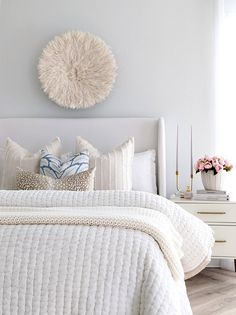 a bedroom with white bedding and pillows