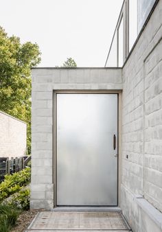 an entrance to a house with brick walls and concrete steps leading up to the front door