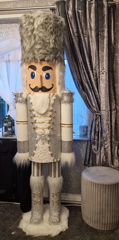 a large nutcracker standing next to a window