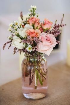 a vase filled with pink and white flowers on top of a table