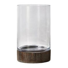 This simple clear glass cylinder vase is perfect for displaying your lovely blossoms and offers a pleasing accent to any rustic decor. Its thick glass walls and weighted wooden base ensure durability. The wooden base gives it a rustic look and feel, making it suitable for outdoor use. This vase can be used as a centerpiece for weddings or other special occasions. Can also be used as a pillar candle holder or left as a standalone for a sophisticated look. Sold individually, this vase measures 9" Tall Glass Vase, Glass Cylinder Vases, Pillar Candle Holder, Glass Walls, Glass Cylinder, Cylinder Vase, Pillar Candle Holders, Pillar Candle, Wooden Base