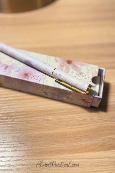 two pens sitting on top of a wooden desk