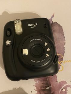 an instax mini camera sitting on top of a wall