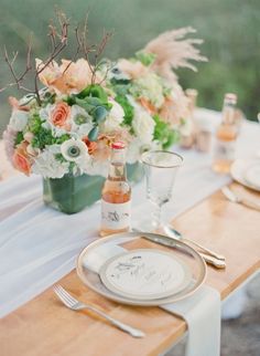 the table is set with white and orange flowers