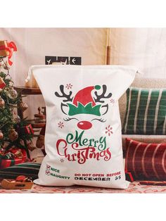 a christmas pillow sitting on top of a couch next to a christmas tree