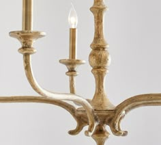 an antique chandelier with three candles lit