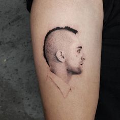 a man with a bald head tattoo on his arm