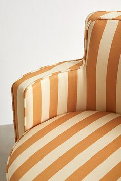 an orange and white striped chair sitting on top of a table