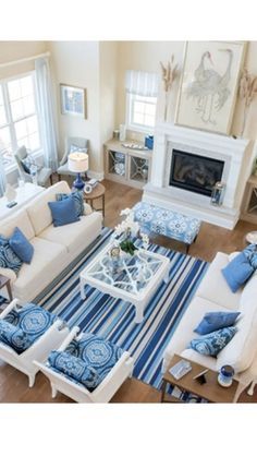 a living room filled with white furniture and blue accents