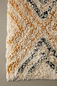 an area rug with various colors and patterns on it, including black, white, yellow and orange