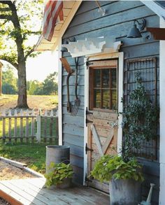 a small blue house with an american flag on the front door and side porch area