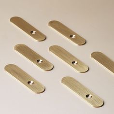 six pieces of brass metal on a white surface