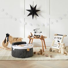 a room filled with toys and decor on top of a wooden floor covered in snowflakes