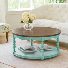 a coffee table with flowers in a vase on top