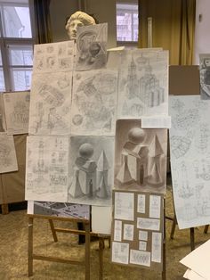 many drawings are displayed on easels in an art studio