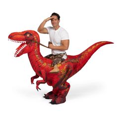 a man riding on the back of a red dinosaur costume