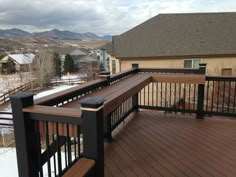 a wooden deck with black railings and brown wood balconies on the side