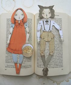 an open book with paper cutouts of people and animals on it's pages