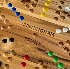 a wooden board game with several different colored dots and the words gunningham family on it