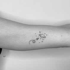 a person's arm with a small space tattoo on the left side of their arm