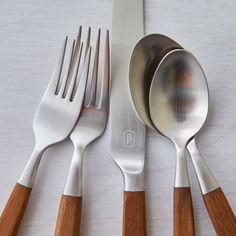 four spoons, two forks and one knife on a table