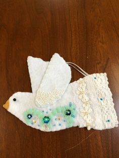 a white bird ornament sitting on top of a wooden table next to a string